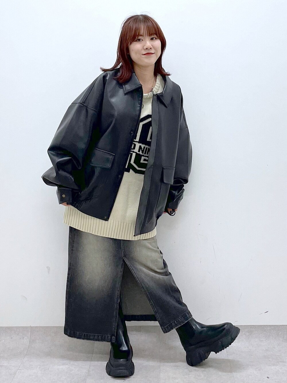 ブラック系のブーツ、ブラック系のスカート、ブラック系のブルゾンを着用したレディースの秋コーディネートの1枚目の写真