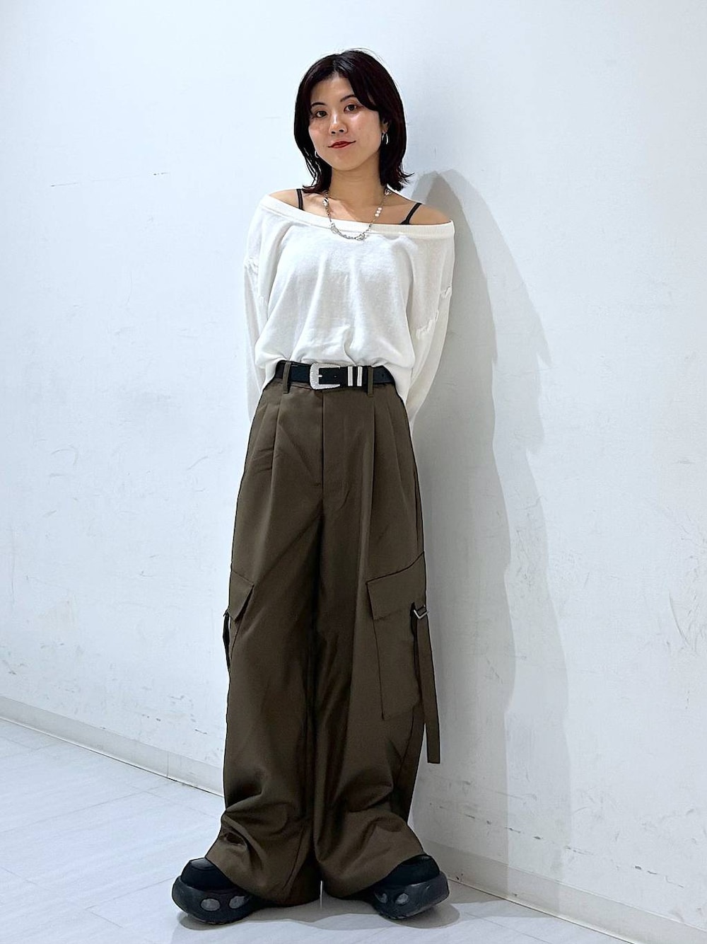 ホワイト系のTシャツ/カットソー、ブラウン系のスラックス、ブラック系のベルトを着用したレディースの秋コーディネートの1枚目の写真