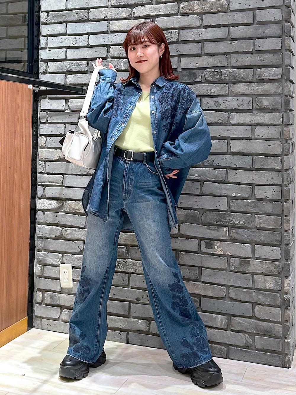 ブルー系のデニムパンツ、ブラック系のスニーカー、ブルー系のシャツ/ブラウスを着用したレディースの冬コーディネートの1枚目の写真