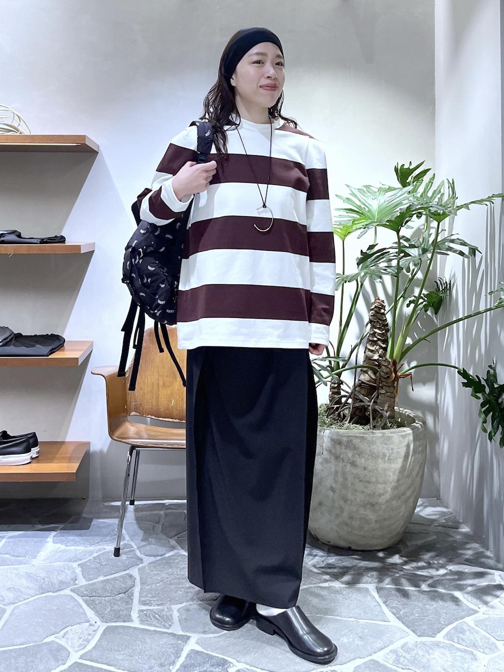 ブラック系のスカート、ブラック系のサンダル、ブラック系のバックパック/リュックを着用したレディースの春コーディネートの1枚目の写真