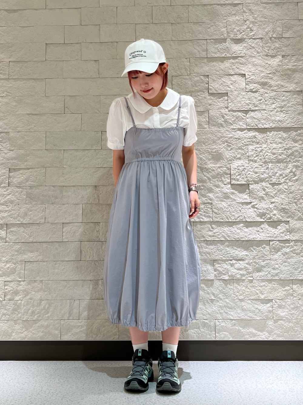 グレー系のワンピース/ドレス、グレー系のスニーカー、ホワイト系のキャップを着用したレディースの夏コーディネートの1枚目の写真