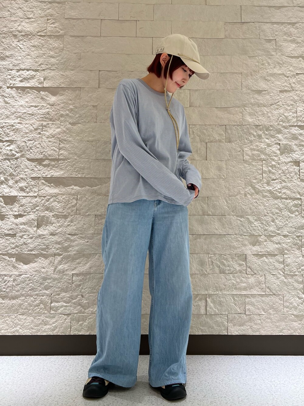 ブルー系のスニーカー、ベージュ系のキャップを着用したレディースの春コーディネートの1枚目の写真