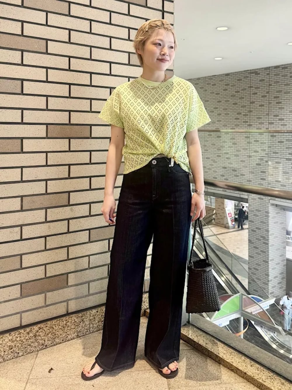 ブラウン系のサンダル、グリーン系のTシャツ/カットソー、ブルー系のデニムパンツを着用したレディースの春コーディネートの1枚目の写真