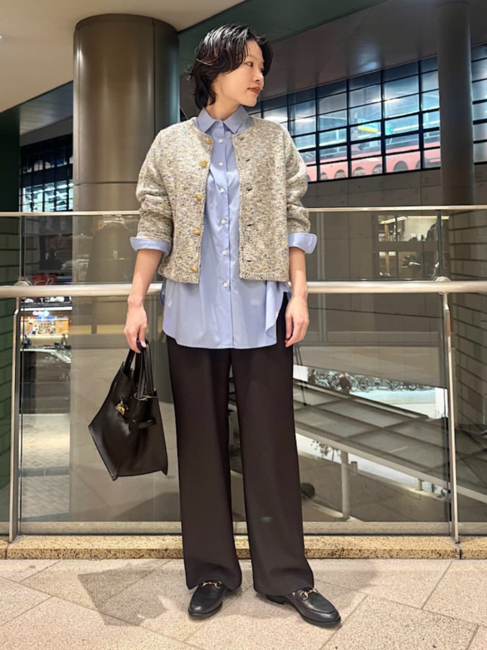 ブルー系のシャツ/ブラウス、ブラック系のトートバッグ、ベージュ系のカーディガン/ボレロを着用したレディースの秋コーディネートの1枚目の写真