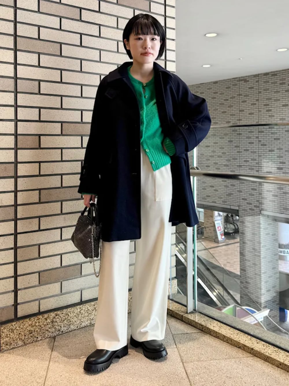 ブラック系のブーツ、ブラック系のショルダーバッグ、ブルー系のステンカラーコートを着用したレディースの冬コーディネートの1枚目の写真