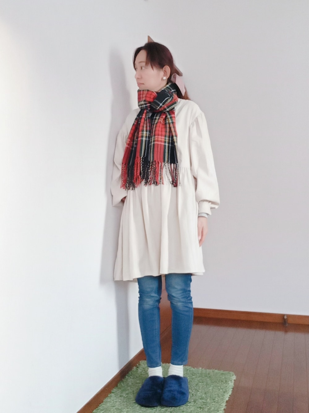 ホワイト系のワンピース、ブルー系のデニムパンツ、その他のマフラーを着用したレディースの冬コーディネートの1枚目の写真