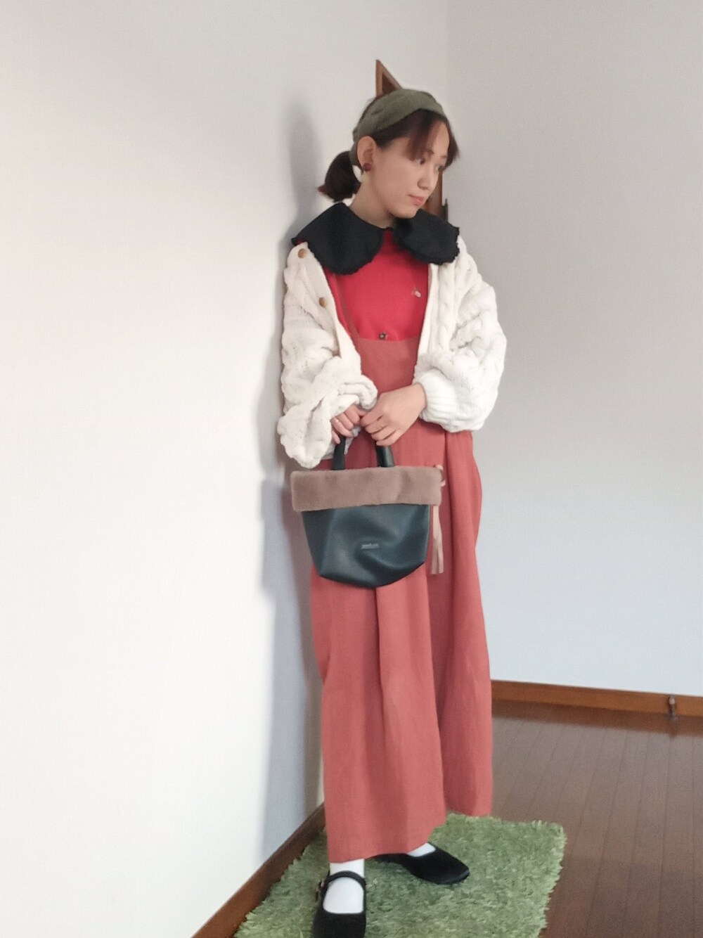 レッド系のニット/セーター、オレンジ系のその他パンツ、ブラック系のTシャツ/カットソーを着用したレディースの冬コーディネートの2枚目の写真
