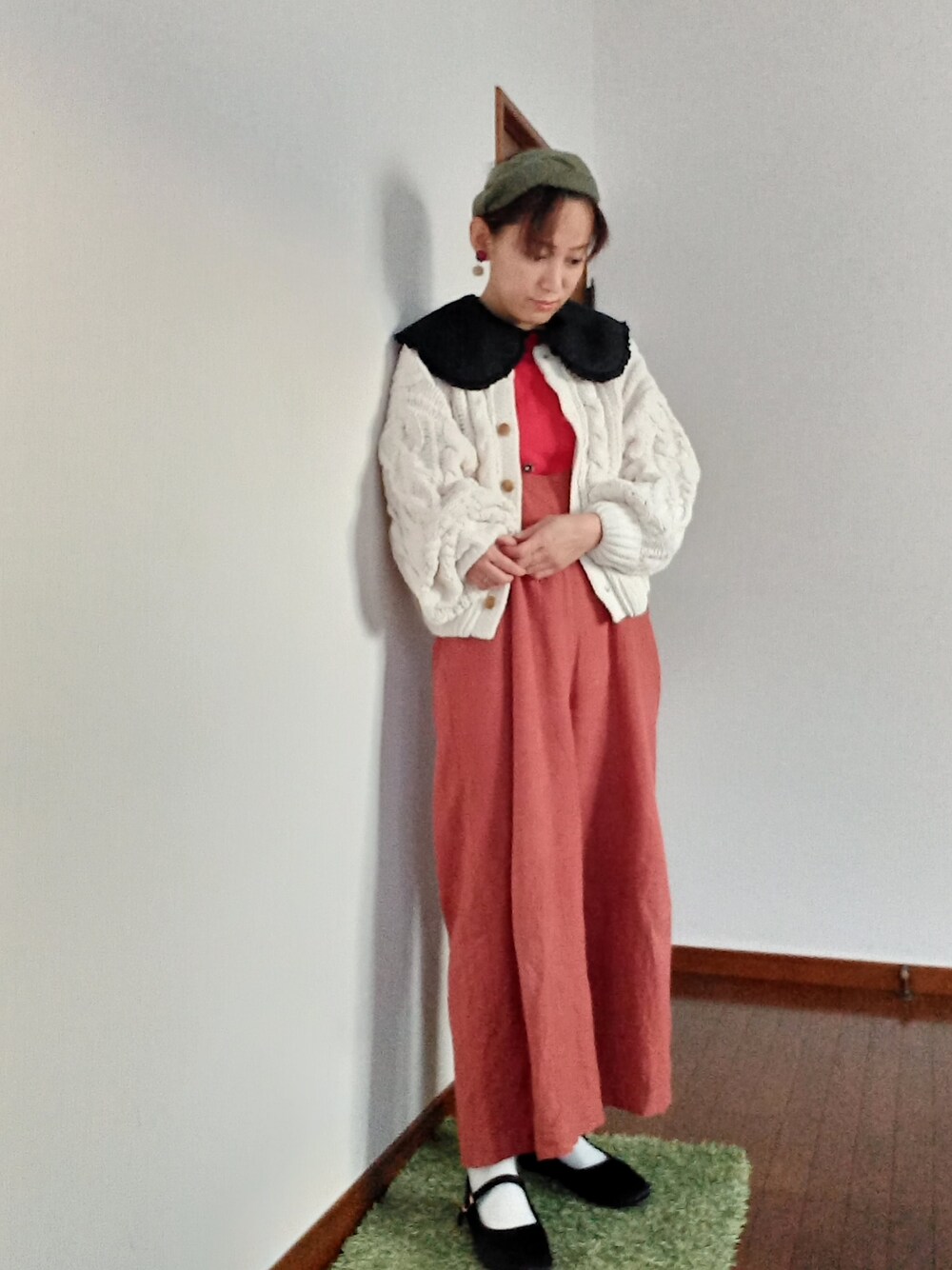 レッド系のニット/セーター、オレンジ系のその他パンツ、ブラック系のTシャツ/カットソーを着用したレディースの冬コーディネートの1枚目の写真