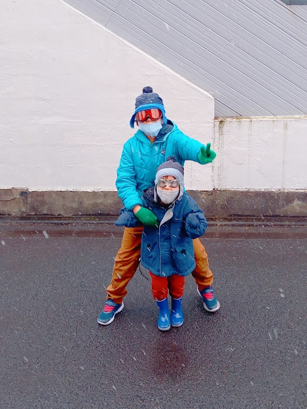 ブルー系のダウンジャケット/コート、ブルー系のジャケット/アウター、ブラウン系のチノパンツを着用したキッズの冬コーディネートの1枚目の写真