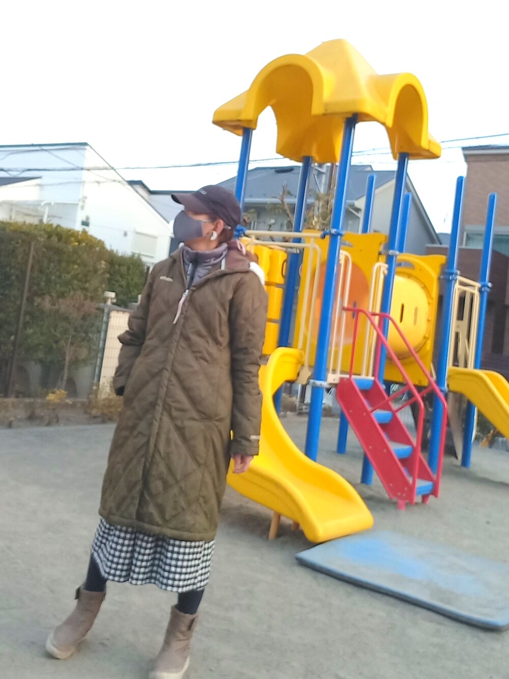 グリーン系のダウンジャケット/コート、ブラック系のワンピース、ベージュ系のブーツを着用したレディースの冬コーディネートの2枚目の写真