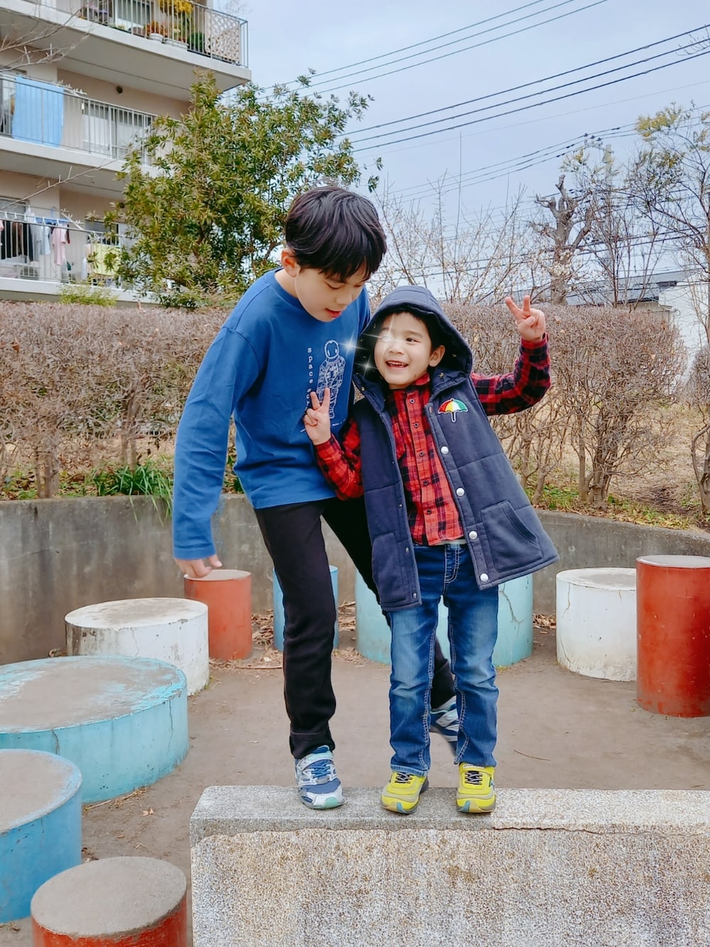 ブルー系のダウンベスト、ブルー系のTシャツ/カットソー、レッド系のシャツ/ブラウスを着用したキッズの冬コーディネートの1枚目の写真