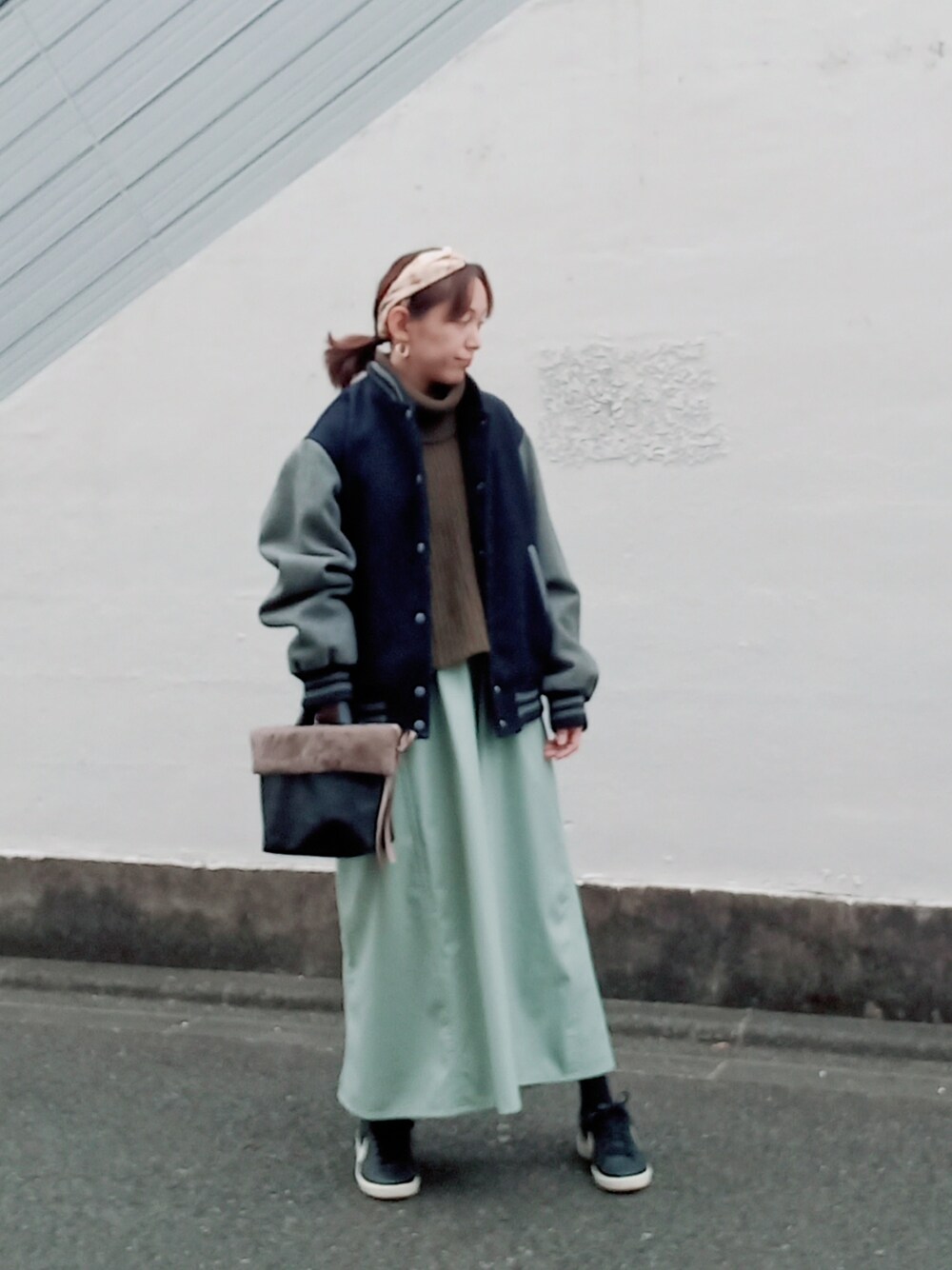 ブルー系のスタジャン、グリーン系のニット/セーター、ブルー系のワンピースを着用したレディースの冬コーディネートの2枚目の写真