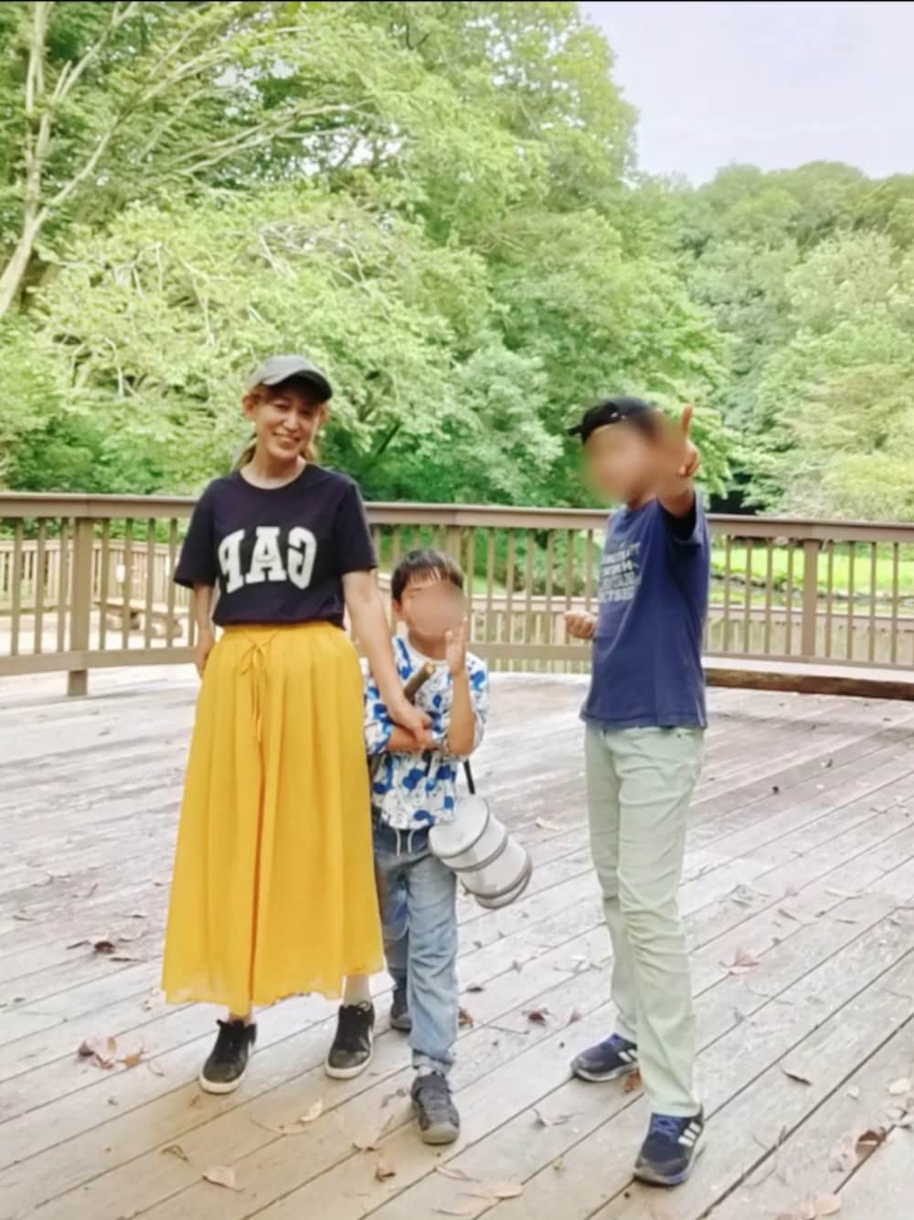 ブルー系のTシャツ/カットソー、イエロー系のパンツ、ブラック系のスニーカーを着用したレディースの夏コーディネートの1枚目の写真