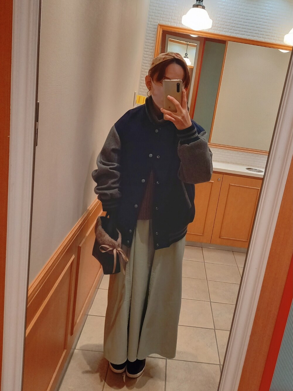 ブルー系のスタジャン、グリーン系のニット/セーター、ブルー系のワンピースを着用したレディースの冬コーディネートの3枚目の写真