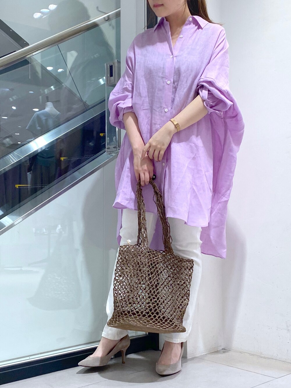 ベージュ系のショルダーバッグ、ホワイト系のシャツ/ブラウス、ホワイト系のデニムパンツを着用したレディースの夏コーディネートの1枚目の写真