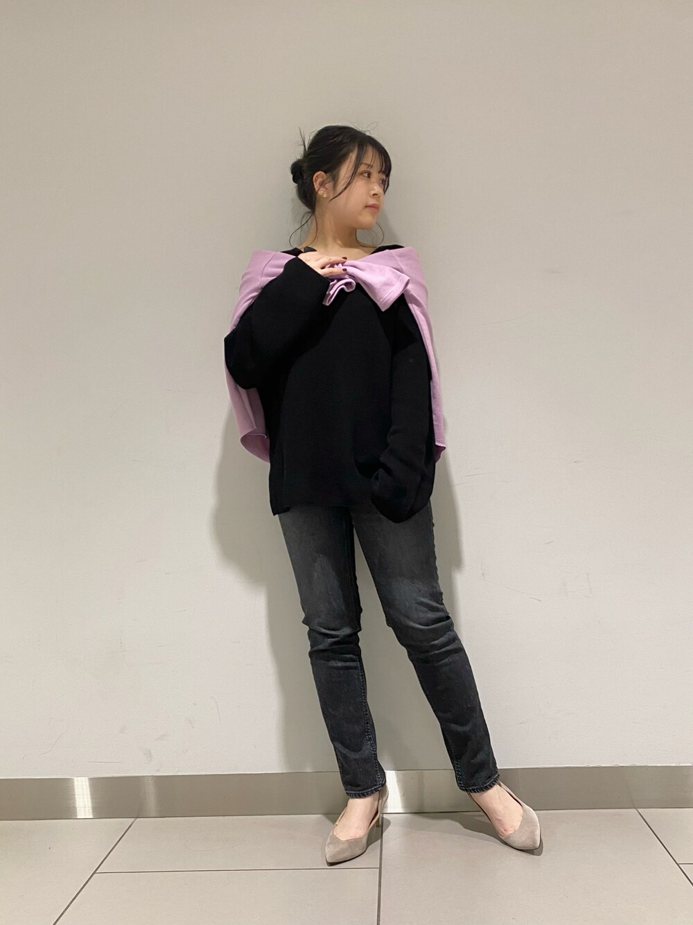 ブラック系のデニムパンツ、ベージュ系のニット/セーター、ピンク系のTシャツ/カットソーを着用したレディースの冬コーディネートの1枚目の写真