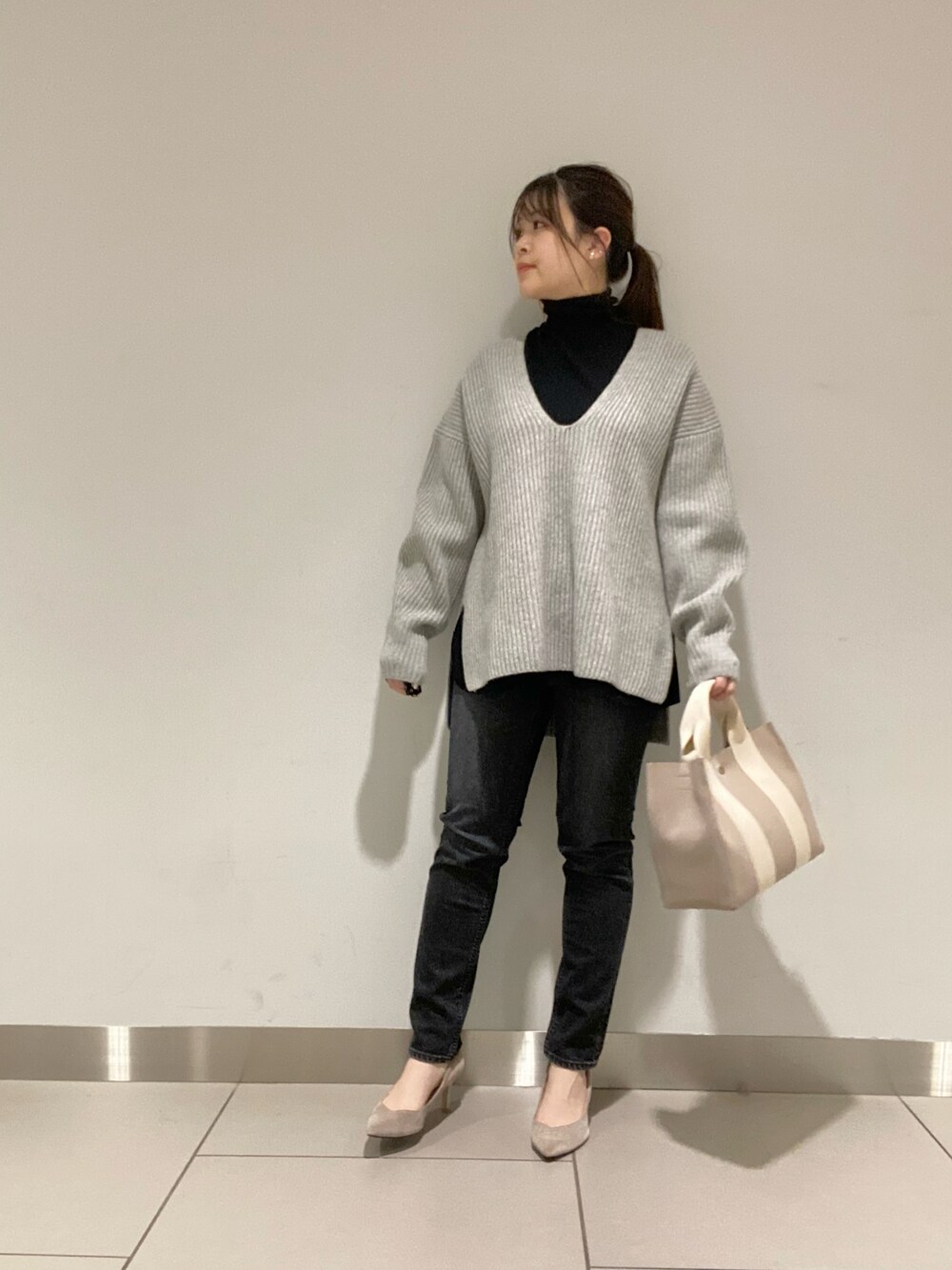 ブラック系のデニムパンツ、ホワイト系のニット/セーター、ブラック系のニット/セーターを着用したレディースの冬コーディネートの1枚目の写真