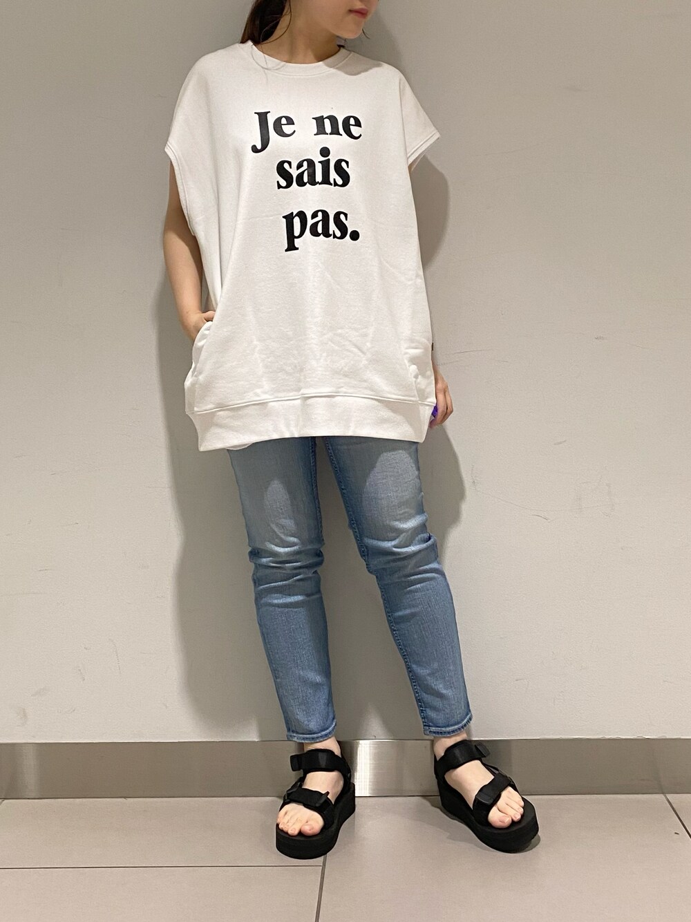 ホワイト系のTシャツ/カットソー、ブルー系のデニムパンツ、ブラック系のその他シューズを着用したレディースの春コーディネートの1枚目の写真