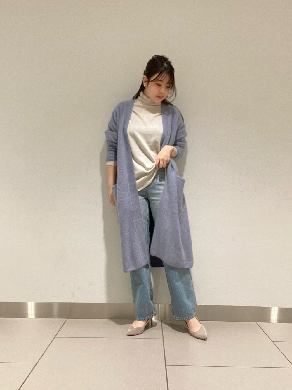 ブルー系のデニムパンツ、ホワイト系のニット/セーター、グレー系のカーディガン/ボレロを着用したレディースの冬コーディネートの1枚目の写真