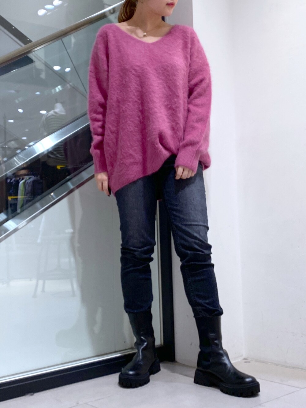 ブラック系のデニムパンツ、グリーン系のニット/セーター、ブラック系のブーツを着用したレディースの秋コーディネートの1枚目の写真