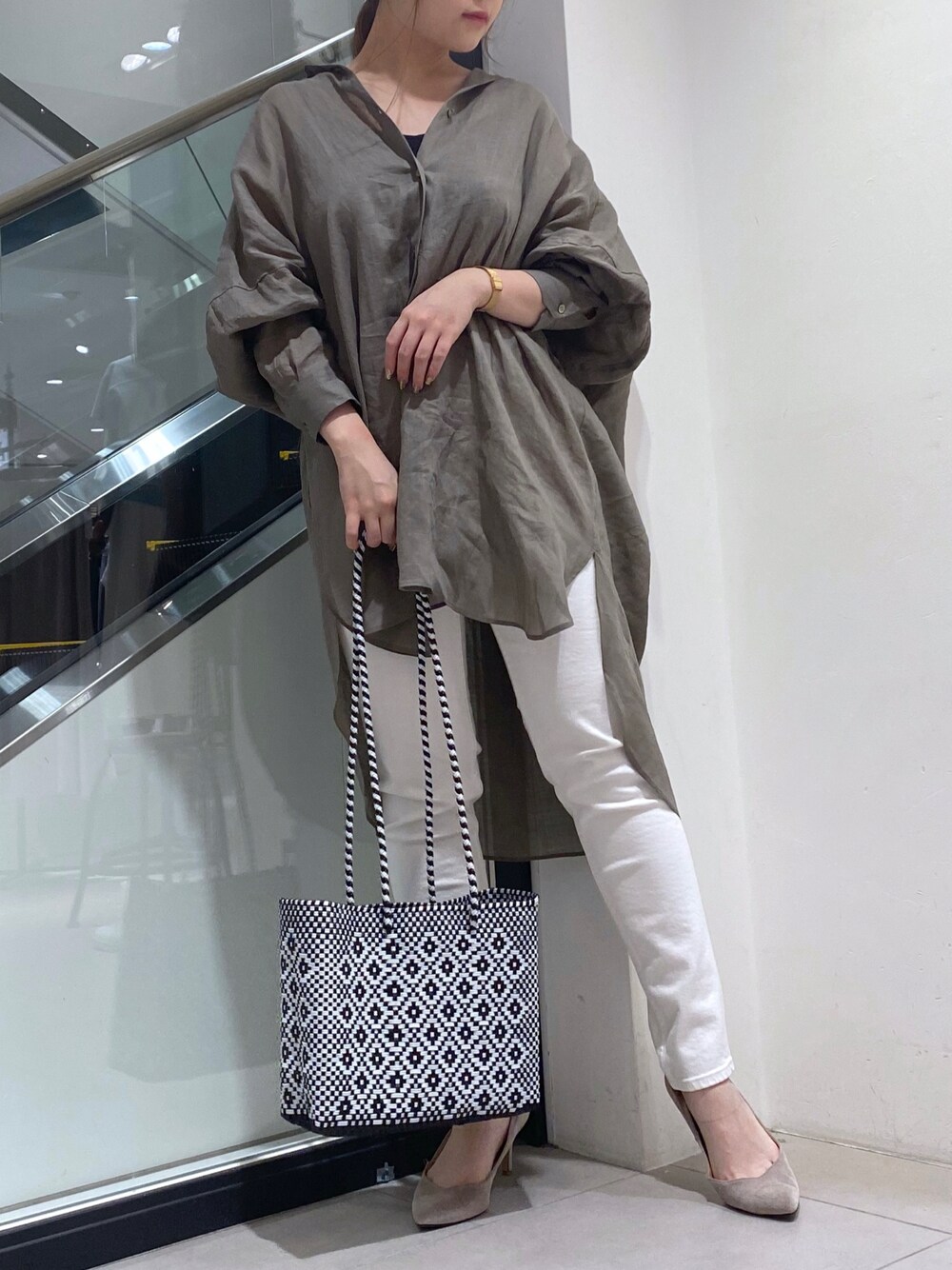 ホワイト系のトートバッグ、グリーン系のシャツ/ブラウス、ホワイト系のデニムパンツを着用したレディースの夏コーディネートの1枚目の写真