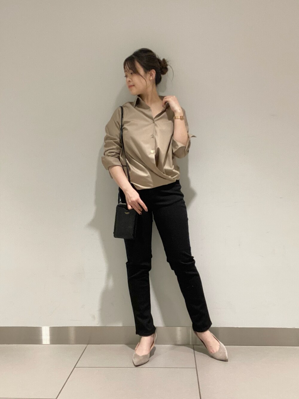 ブラック系のデニムパンツ、ベージュ系のシャツ/ブラウス、ブラック系のショルダーバッグを着用したレディースの冬コーディネートの1枚目の写真