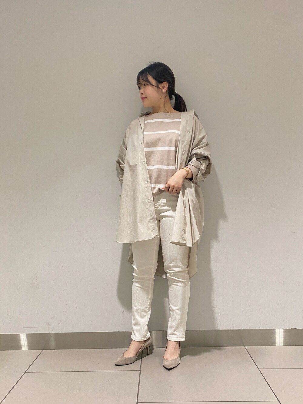 ホワイト系のデニムパンツ、ベージュ系のTシャツ/カットソー、イエロー系のシャツ/ブラウスを着用したレディースの春コーディネートの1枚目の写真