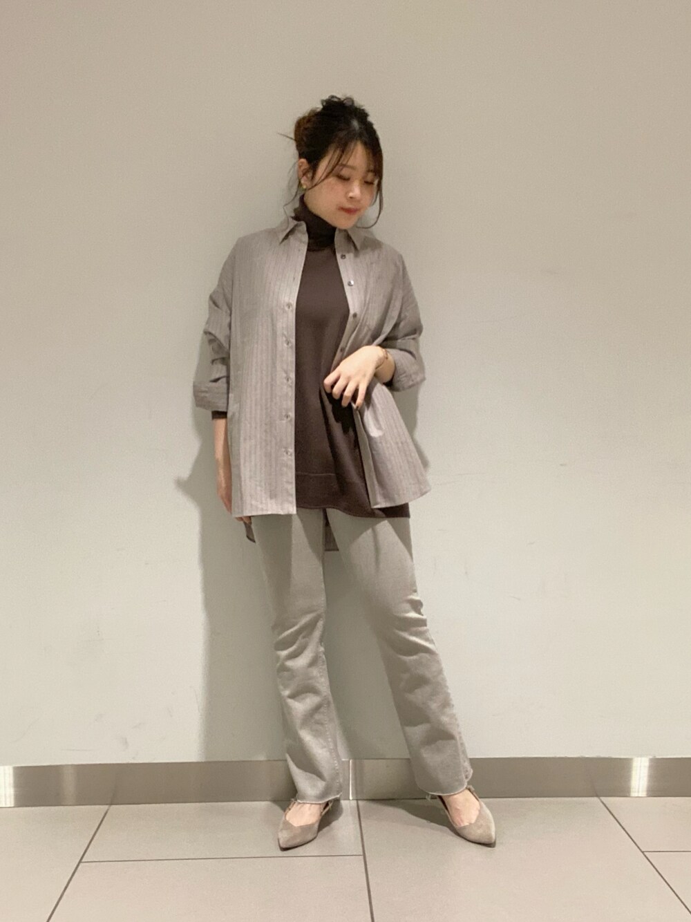 グレー系のデニムパンツ、グレー系のシャツ/ブラウス、ホワイト系のニット/セーターを着用したレディースの冬コーディネートの1枚目の写真