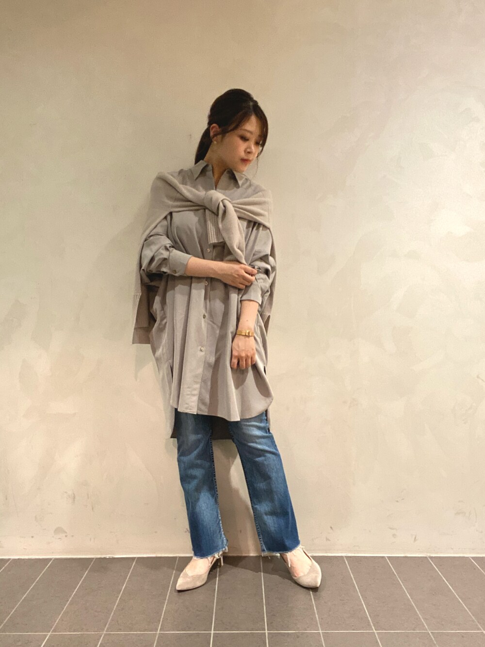 ベージュ系のシャツ/ブラウス、ブルー系のデニムパンツ、ベージュ系のニット/セーターを着用したレディースの秋コーディネートの1枚目の写真