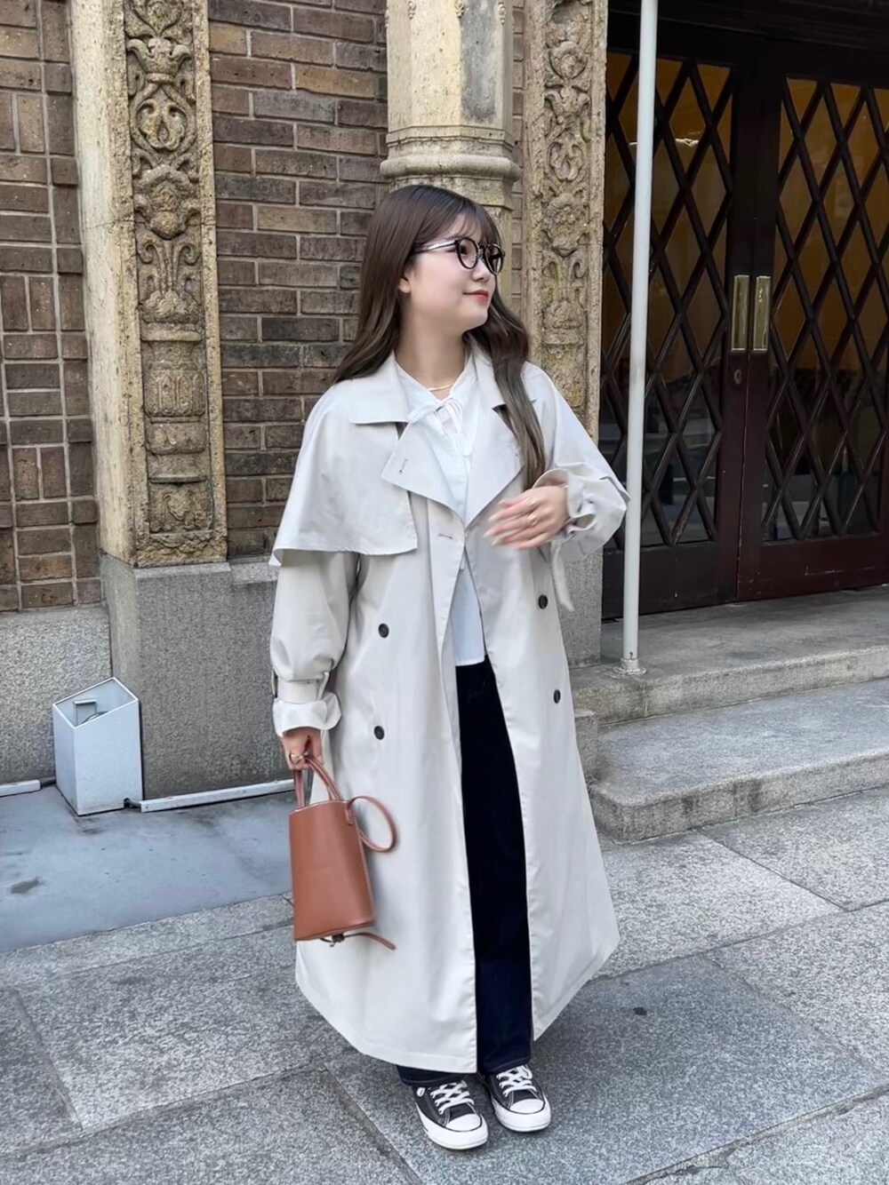 ホワイト系のシャツ/ブラウス、ベージュ系のトレンチコートを着用したレディースの冬コーディネートの1枚目の写真