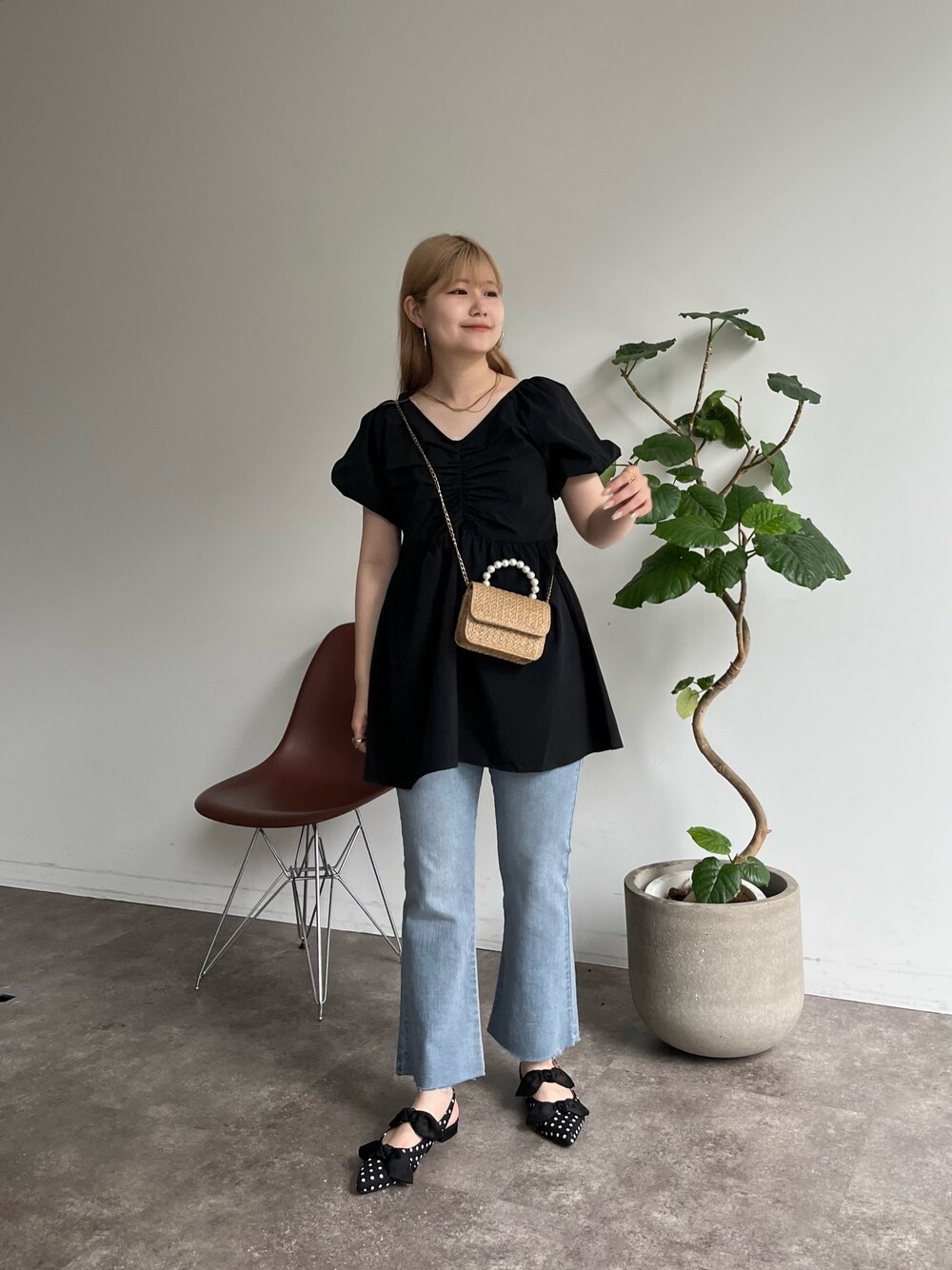 ベージュ系のショルダーバッグ、ブルー系のデニムパンツ、ブラック系のパンプスを着用したレディースの夏コーディネートの1枚目の写真