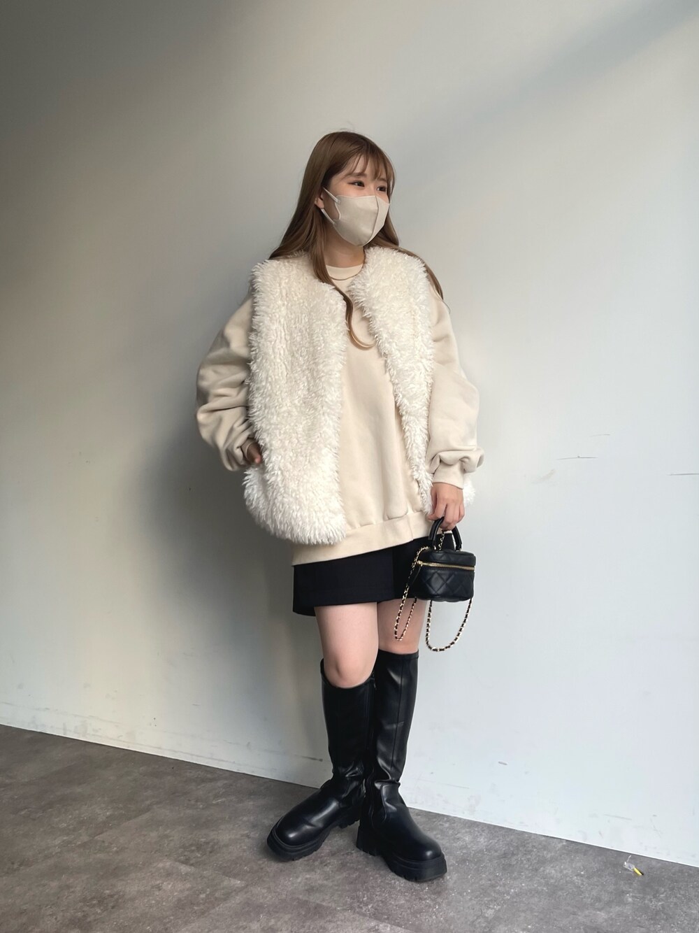 ホワイト系のスウェット、ホワイト系のベスト、ブラック系のその他パンツを着用したレディースの秋コーディネートの1枚目の写真