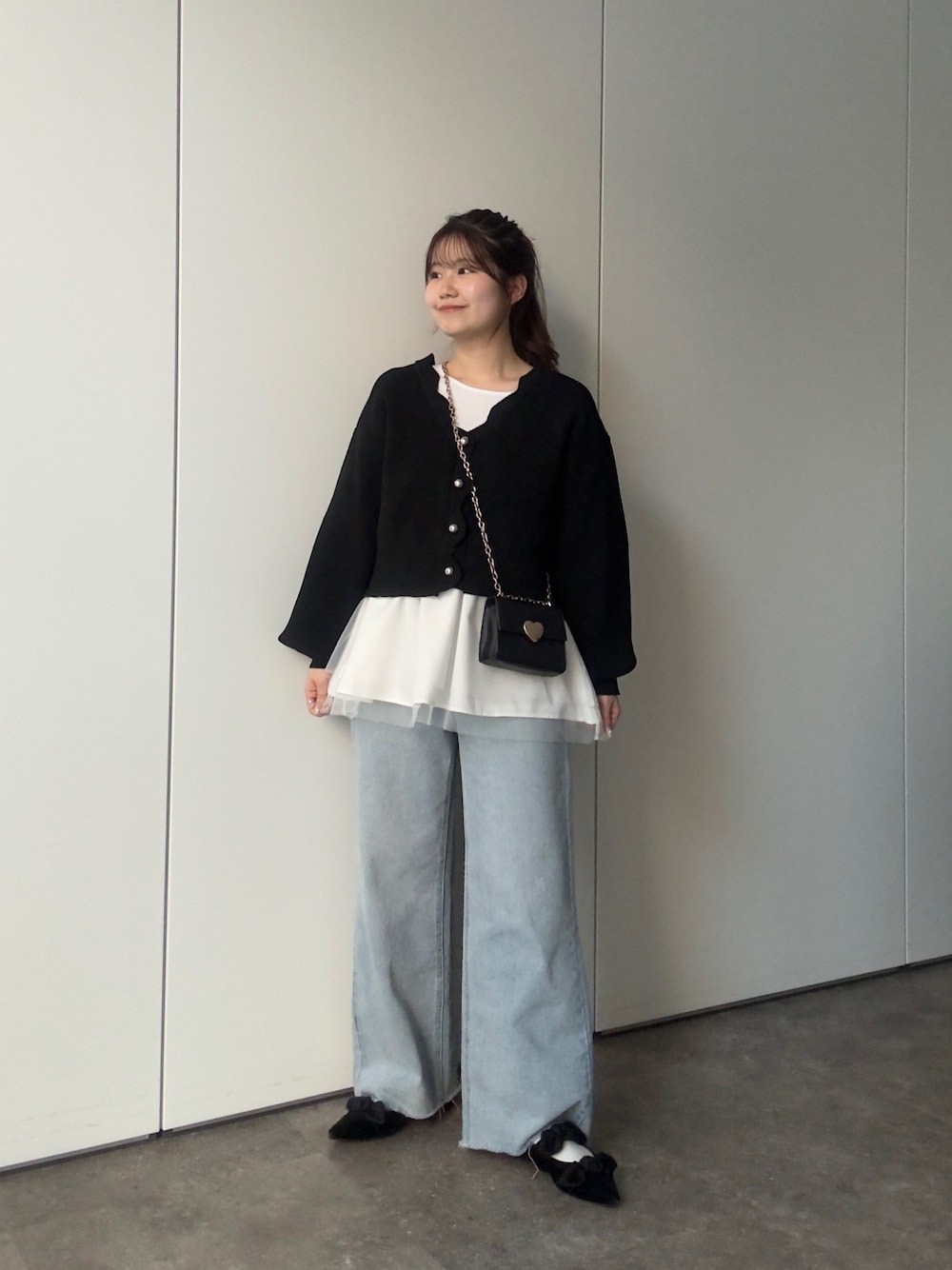 ブラック系のカーディガン/ボレロ、ホワイト系のTシャツ/カットソー、ブルー系のデニムパンツを着用したレディースの冬コーディネートの1枚目の写真