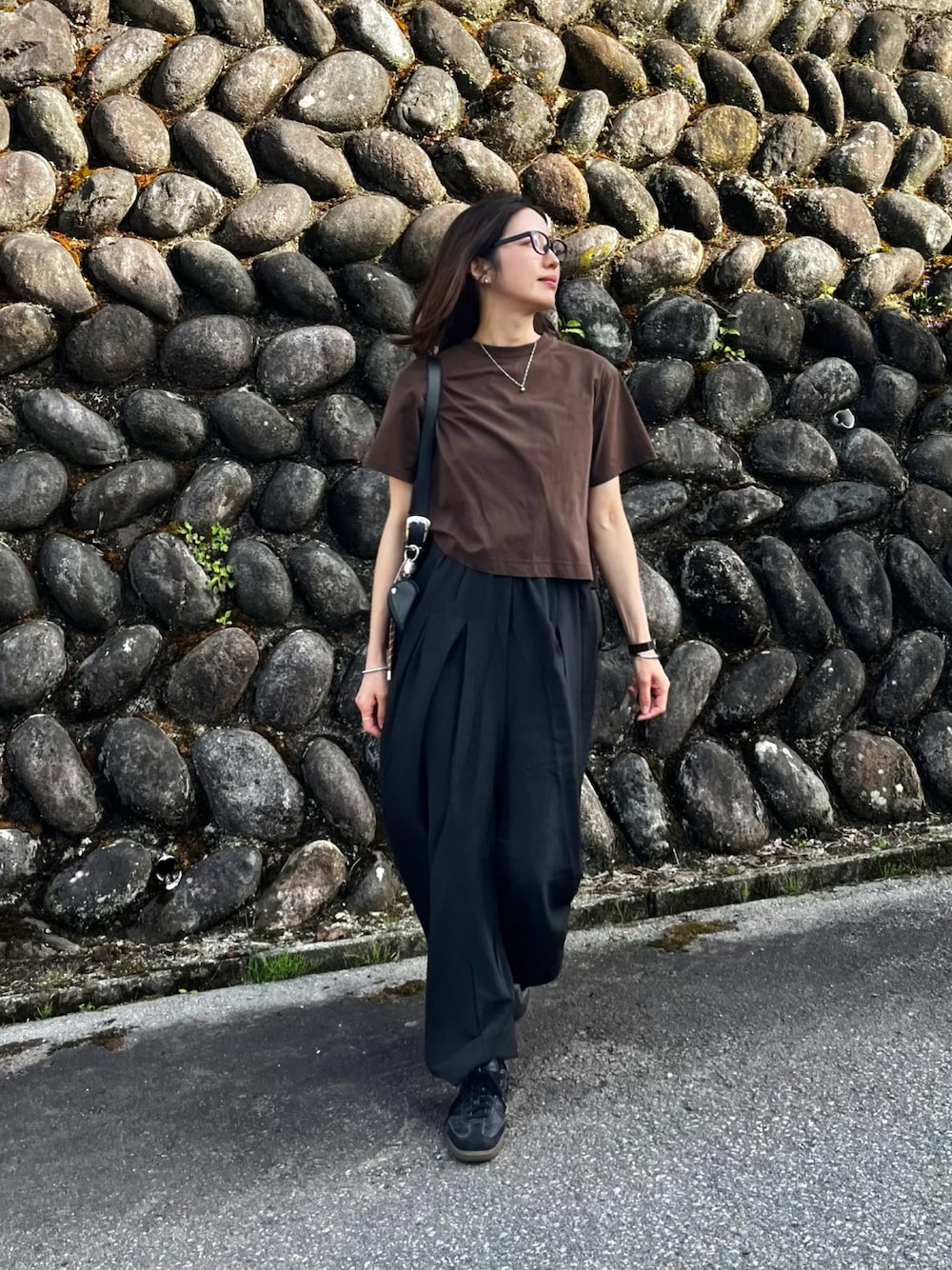 ブラック系のその他パンツ、ブラウン系のニット/セーター、ブラック系のバッグを着用したレディースの春コーディネートの1枚目の写真