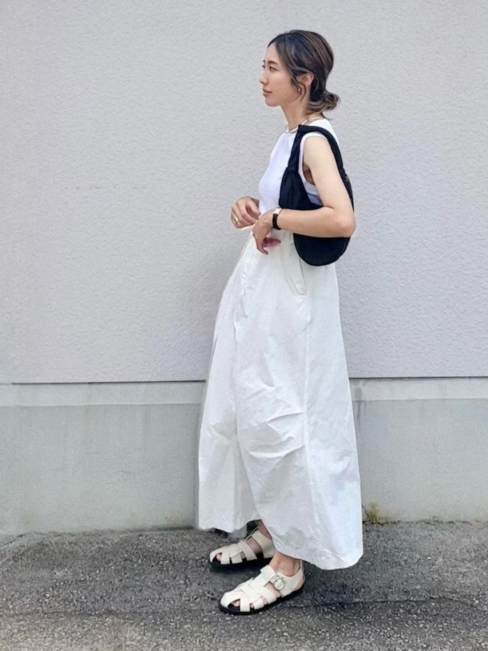 ホワイト系のスカート、ブラック系のTシャツ/カットソー、ホワイト系のサンダルを着用したレディースの夏コーディネートの1枚目の写真