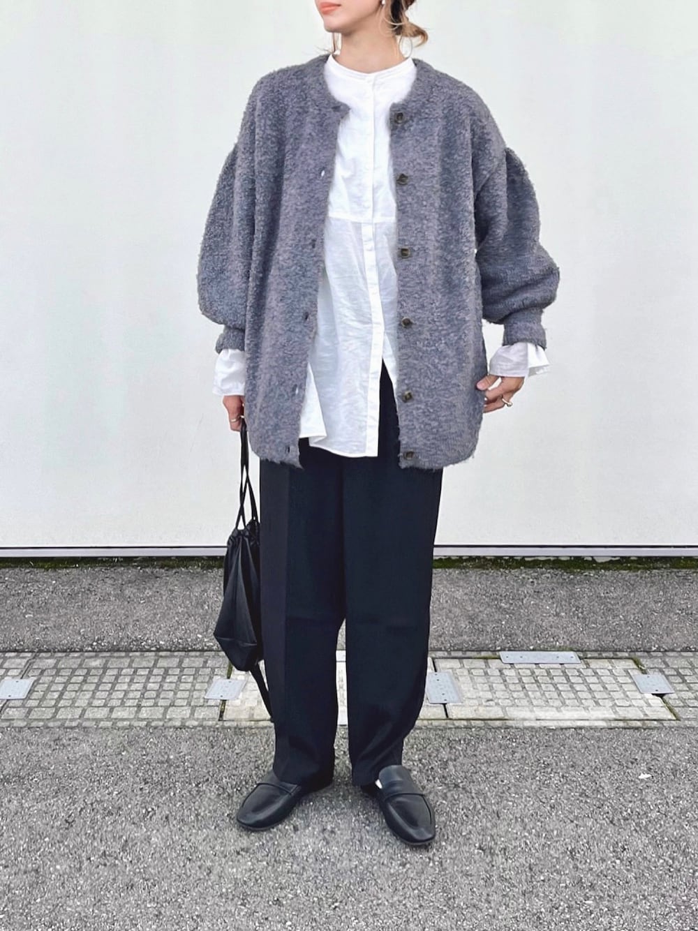 パープル系のカーディガン/ボレロ、ホワイト系のシャツ/ブラウス、ブラック系のスラックスを着用したレディースの秋コーディネートの1枚目の写真