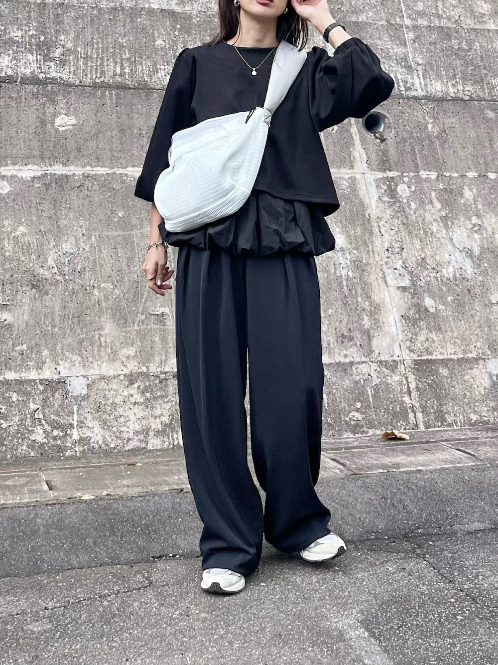 ブラック系のアンサンブル、ホワイト系のボディバッグ/ウエストポーチ、ピンク系の口紅/リップティント/グロスを着用したレディースの秋コーディネートの1枚目の写真