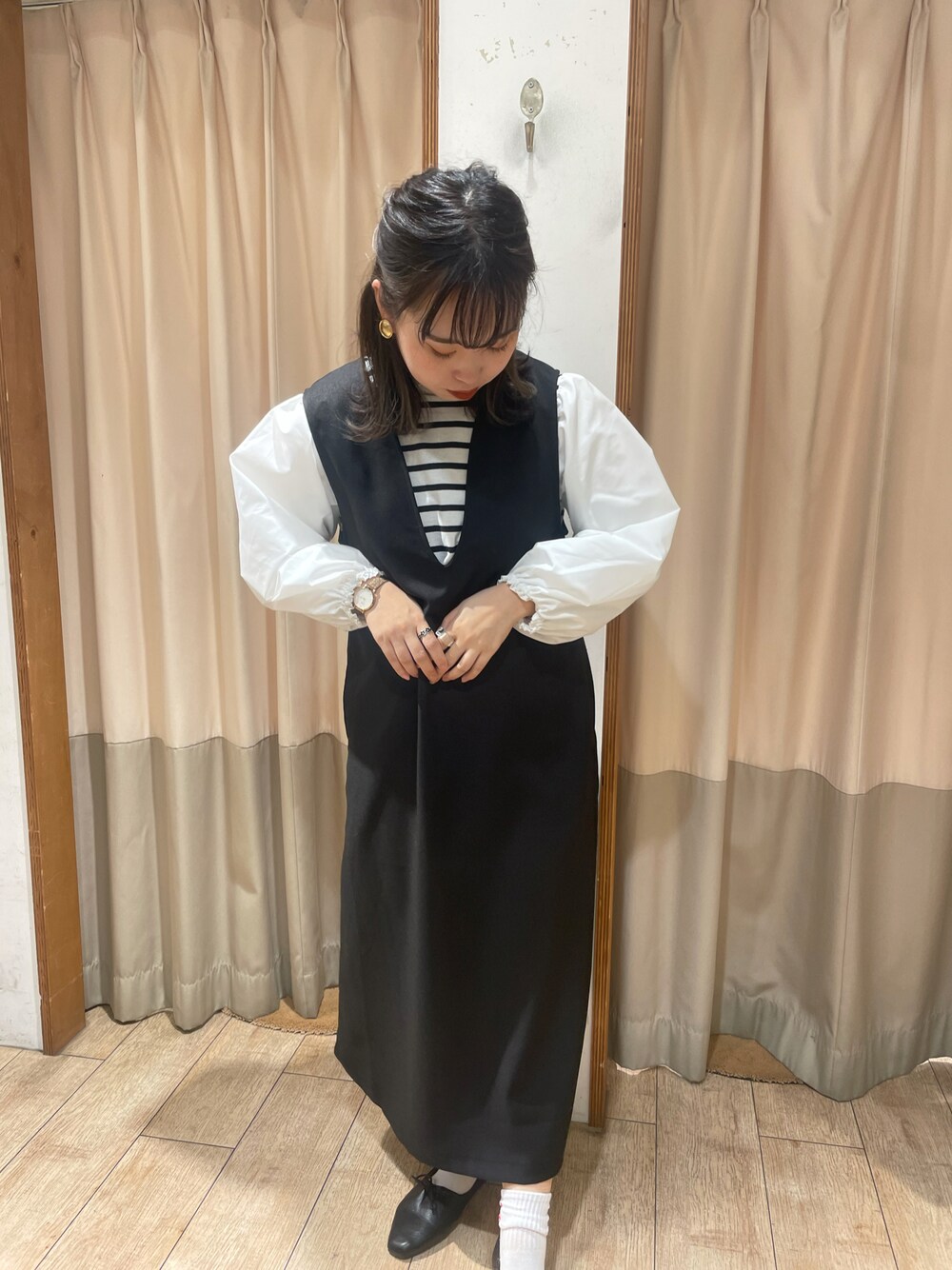 ホワイト系のTシャツ/カットソー、ブラック系のジャンパースカートを着用したレディースの冬コーディネートの1枚目の写真