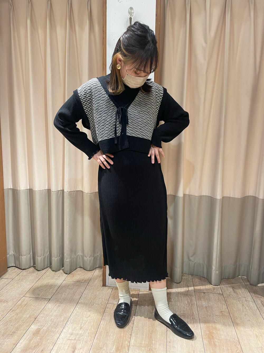ブラック系のワンピース、ブラック系のベストを着用したレディースの冬コーディネートの1枚目の写真