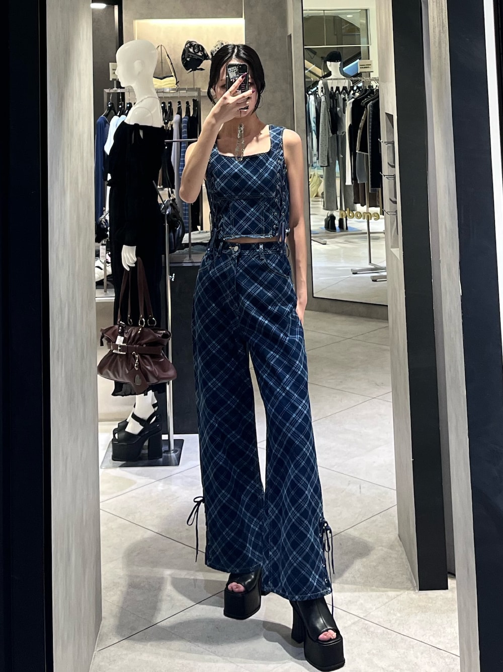 ブルー系のタンクトップ、ブルー系のデニムパンツ、ブラック系のサンダルを着用したレディースの春コーディネートの1枚目の写真