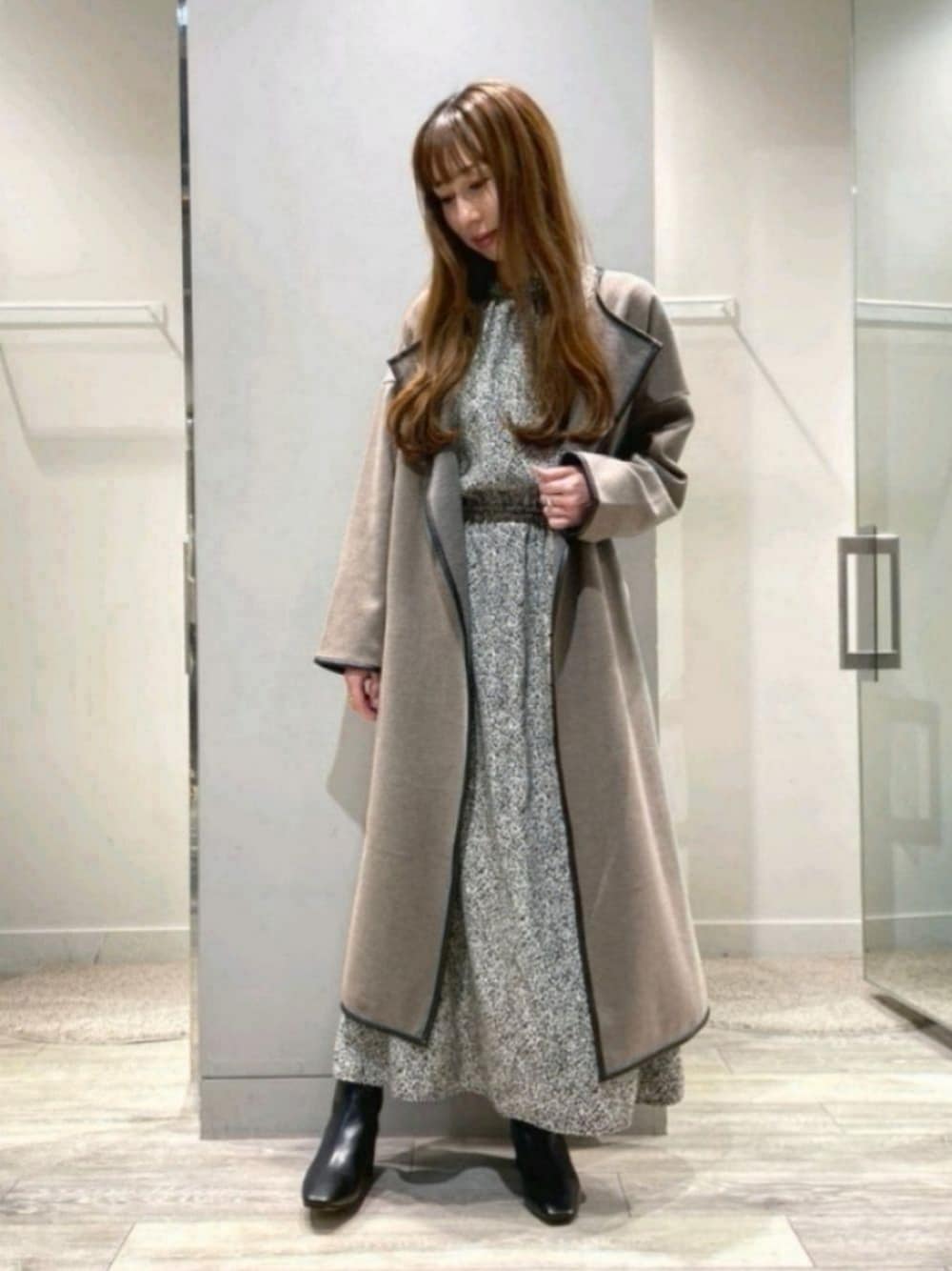 ブラウン系のその他アウター、ブルー系のワンピース、ブラック系のブーツを着用したレディースの秋コーディネートの1枚目の写真