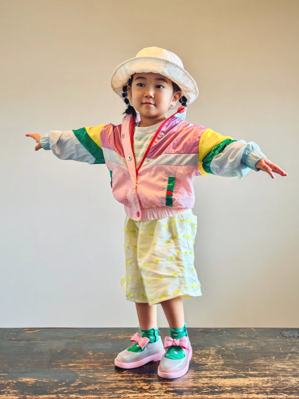 グリーン系のTシャツ/カットソー、ピンク系のセットアップ、イエロー系のパンツを着用したキッズの秋コーディネートの1枚目の写真