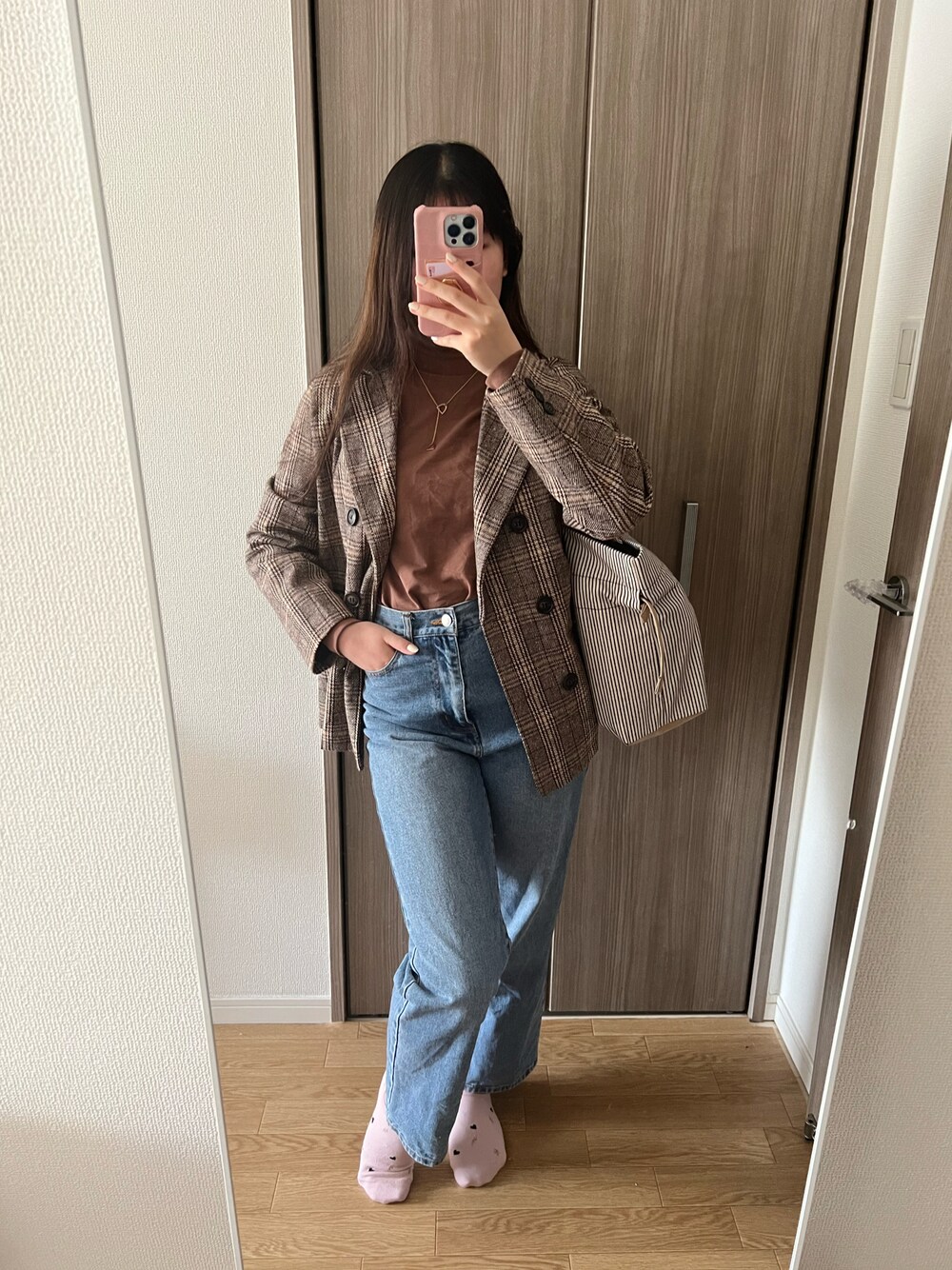 ブラウン系のTシャツ/カットソー、ブラウン系のテーラードジャケット、ブルー系のデニムパンツを着用したレディースの冬コーディネートの1枚目の写真