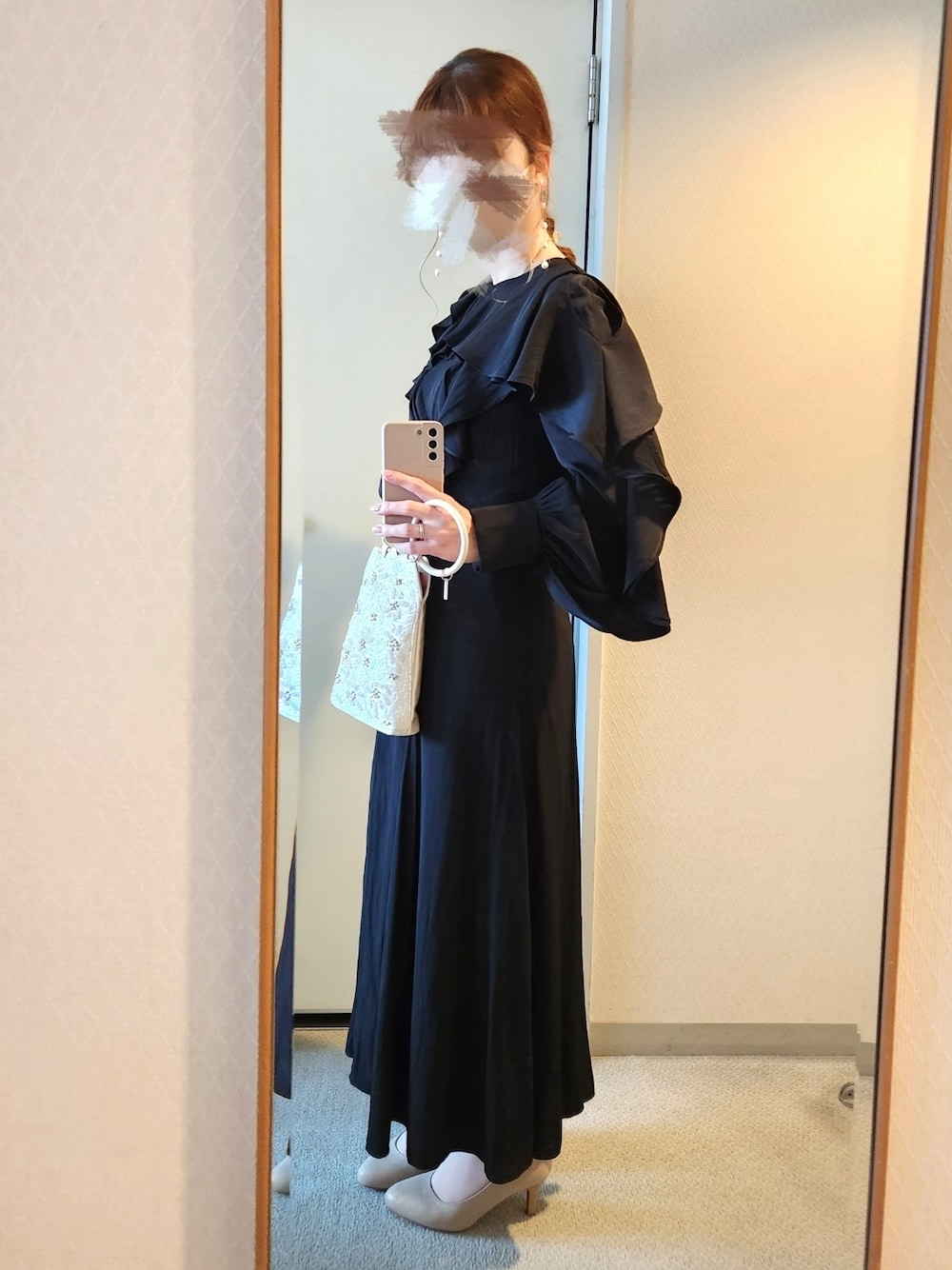 ブラック系のワンピース、ベージュ系のハンドバッグ、ゴールド系のパンプスを着用したレディースの夏コーディネートの1枚目の写真