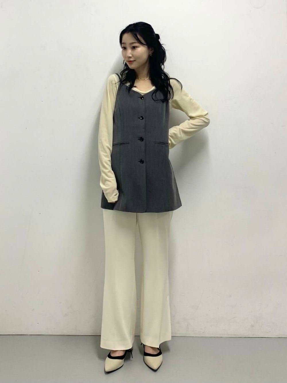 グレー系のチュニック、ホワイト系のパンプス、ホワイト系のTシャツ/カットソーを着用したレディースの秋コーディネートの1枚目の写真