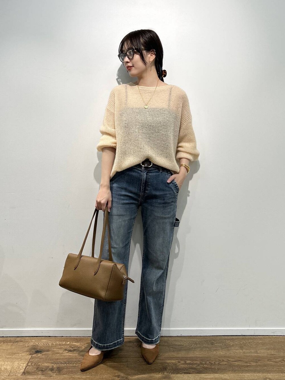 イエロー系のパンプス、ブルー系のデニムパンツ、ベージュ系のニット/セーターを着用したレディースの夏コーディネートの1枚目の写真