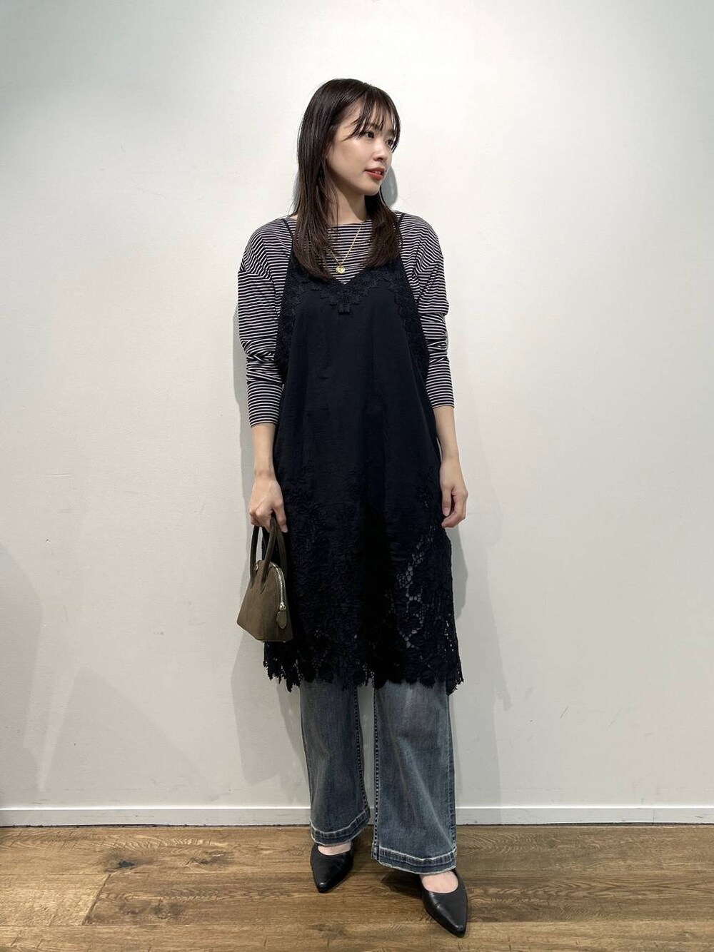 ブラック系のパンプス、ブルー系のデニムパンツ、その他のネックレスを着用したレディースの夏コーディネートの1枚目の写真