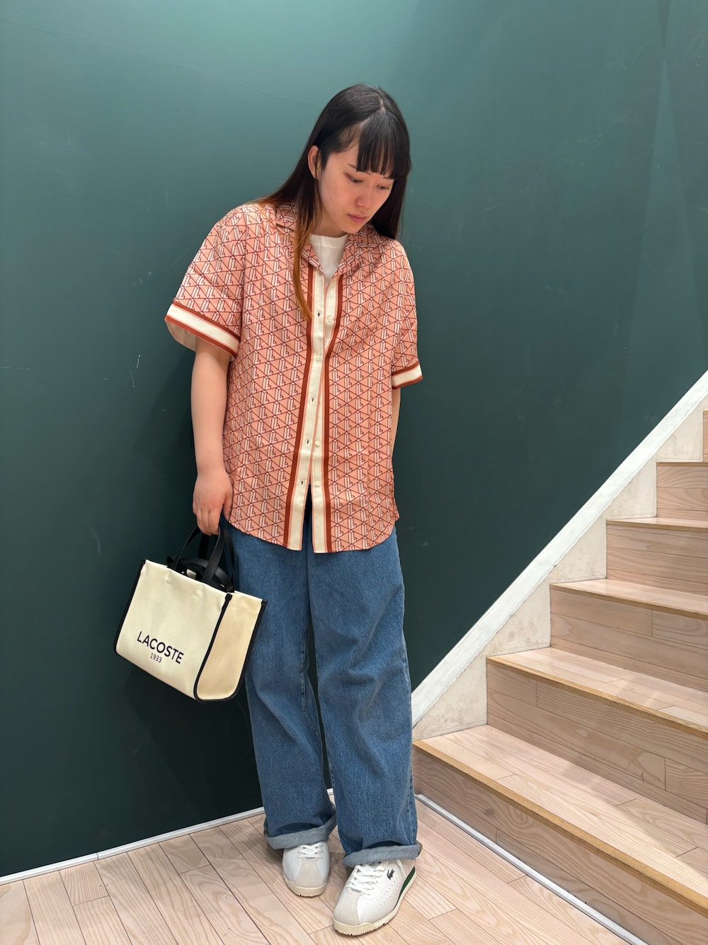 ピンク系のシャツ/ブラウス、ブルー系のデニムパンツ、ホワイト系のスニーカーを着用したレディースの春コーディネートの1枚目の写真