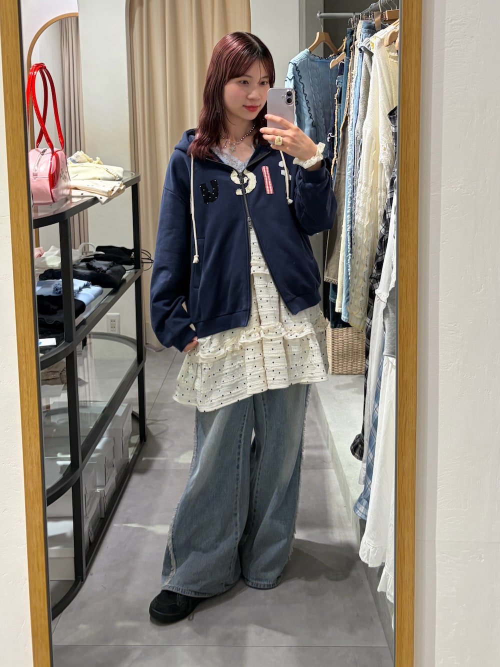 ブルー系のパーカー、ホワイト系のワンピース、ブルー系のデニムパンツを着用したレディースの春コーディネートの1枚目の写真