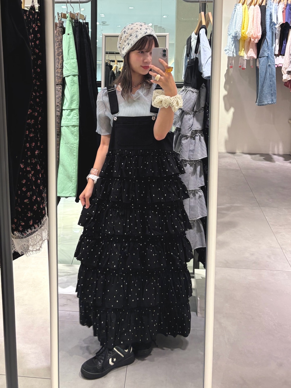 ブラック系のジャンパースカート、ブルー系のシャツ/ブラウス、ホワイト系のキャップを着用したレディースの夏コーディネートの1枚目の写真
